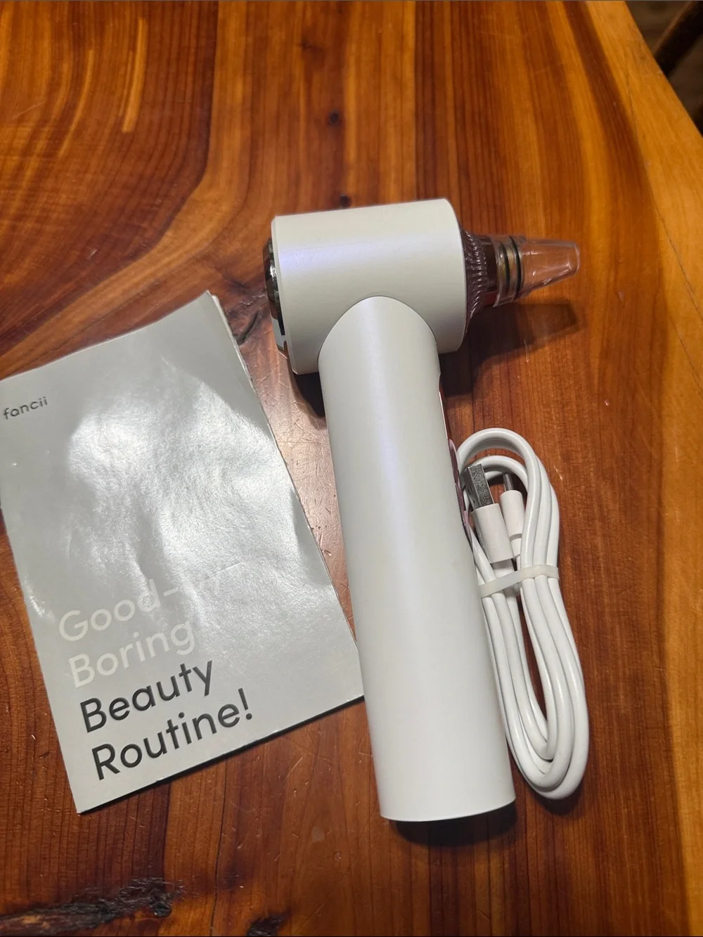 Fancii White & Rose Gold Facial Pore Vacuum and light therapy tool.